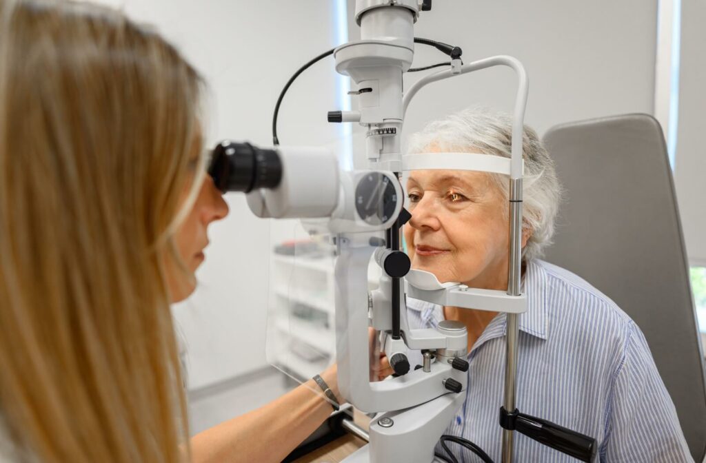 A senior woman having her eye examined by an optometrist using a slit lamp microscope.
